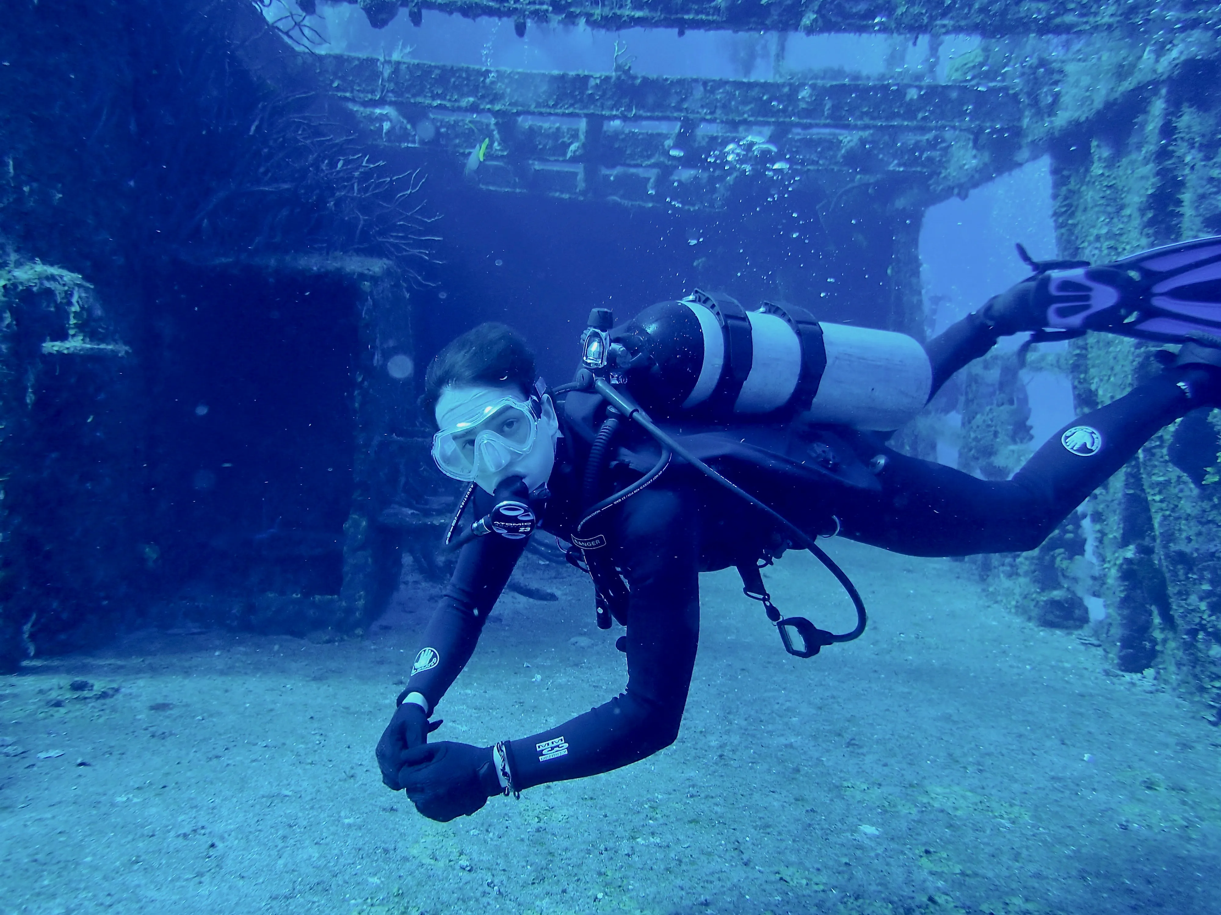 Scuba diving among the beams of a submerged wreck